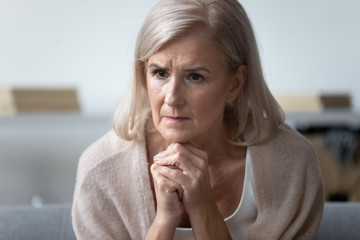 Worried mature woman feel concerned about health problems at home