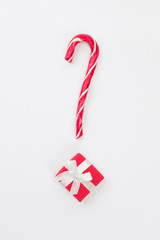 Question mark from Christmas present with candy cane on white background. Gift choice concept. Top view, flat lay, copy space, vertical format