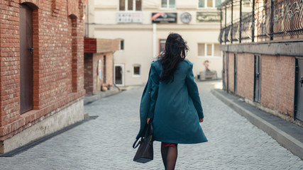 City portrait of beautiful young woman in coat.