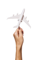 A raised female hand holds an airplane isolated on a white background