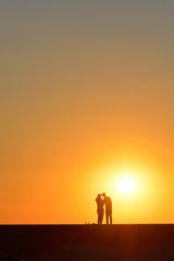 Fototapeta premium Paar im Abendrot am Strand