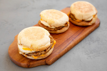 Homemade pork roll egg sandwich on a rustic wooden board on a gray background, low angle view. Closeup.