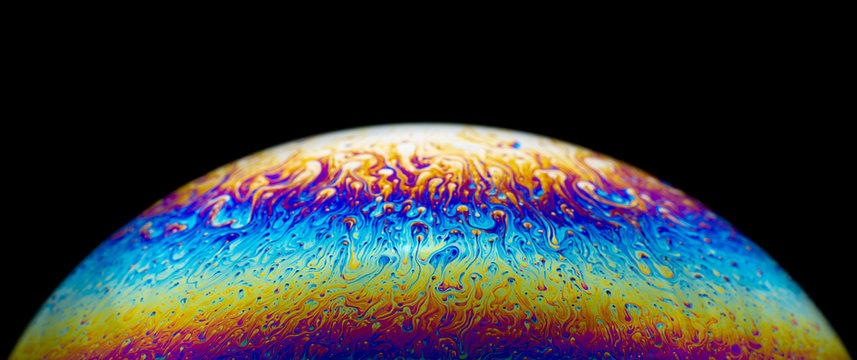 Close up picture of half soap bubble on black background