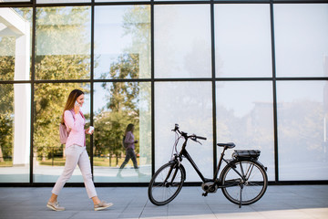 Young woman with ebicycle using on mobile phone