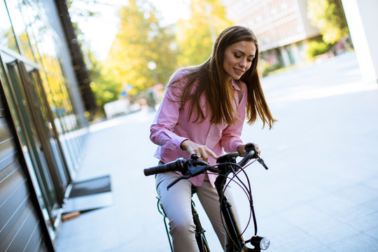 Young woman riding an electric bicycle in urban environment
