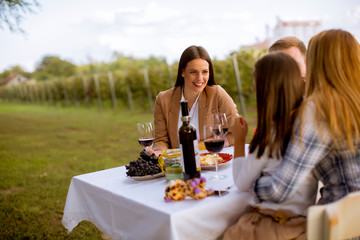 Young people enjoy dinner and wine tasting in the vineyard