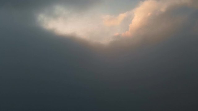 Aerial view flying through cumulus thunderclouds at sunset. Gold colored sunset cloudiness in high contrast. Real sky. The concept of dreams and weather forecast