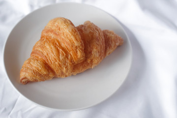 plate of baked croissants on white background.