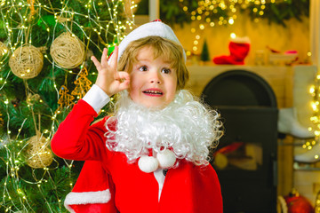 Merry Christmas. Happy child. Boy dressed as Santa Claus at a successful home party. December time.