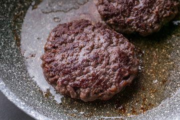 Close-up two appetizing juicy burger on a ceramic pan.