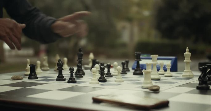 Gentlemen playing chess with a timer at public Parc in Montpellier, France. Cinematic Colors and Depth of Field.