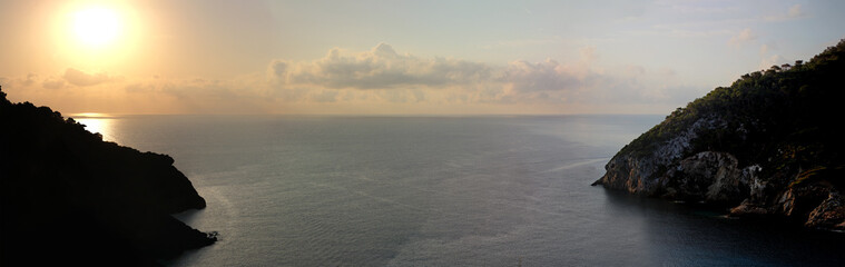 Sunset of balearic island Ibiza with wooden cliffs