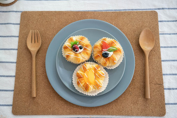 A blue plate of fruit buns on the table -squishy
