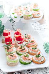 Assorted canapes with shrimps - with fresh cucumbers, cherry tomatoes, bread, crackers on the festive table, selective focus