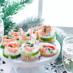 Assorted canapes with shrimps - with fresh cucumbers, cherry tomatoes, bread, crackers at the festive Christmas table, square