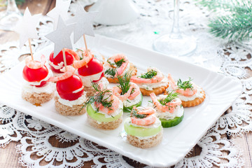 Assorted canapes with shrimps - with fresh cucumbers, cherry tomatoes, bread, crackers on the festive table, horizontal