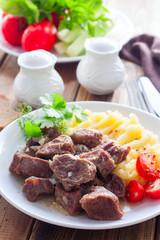Beef stew with mashed potatoes on a white plate, selective focus
