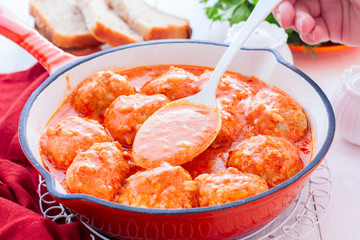Chicken meatballs in a pan in tomato and sour cream sauce, horizontal