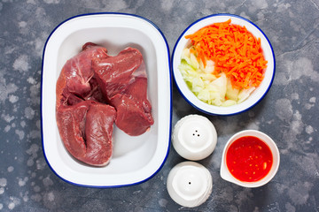 Raw beef heart in enameled shape, top view, selective focus