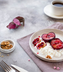 healthy breakfast. yogurt with fruits and nuts in a plate on linen textile, a cup with hot coffee or tea. close-up. gray background, side view