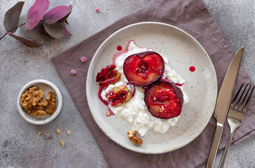 healthy food. yogurt or ricotta with fruits and walnuts in a plate on linen textile, closeup. gray background, top view