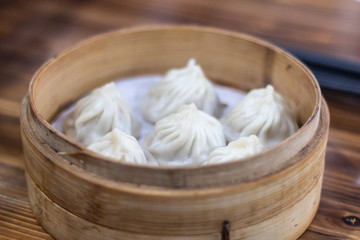 Xiao Long Pao in small bamboo steaming basket.