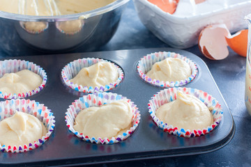 Raw muffins in a metal mold before baking, horizontal