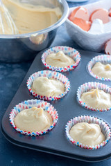 Raw muffins in a metal mold before baking, selective focus