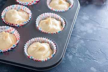 Raw cupcake dough in a cupcake baking dish, horizontal, copy space
