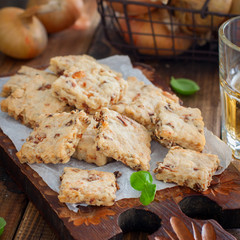 Cracker cookies with fried onions on a wooden board with a glass of beer,square