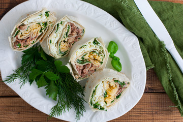 Lavash roll with canned saury, cheese and eggs, selective focus