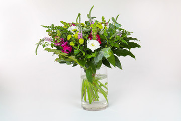 Bouquet of flowers in a vase isolated on white.