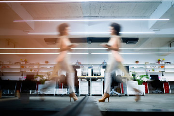 Professional business woman in motion with blur in business office