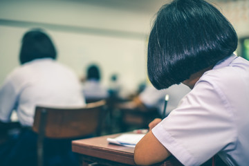 Asian high school students in a white school uniform are serious and tired of exams.
