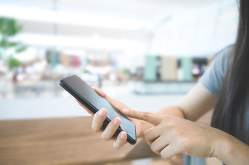 Close up image hand of woman using mobile smart phone in the mall