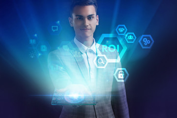 The concept of business, technology, the Internet and the network. A young entrepreneur working on a virtual screen of the future and sees the inscription: ROI