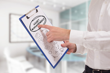 Business, technology, internet and network concept. Young businessman points to the keyword: Asset...