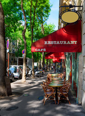 Cozy street with tables of cafe in quarter Montmartre in Paris, France