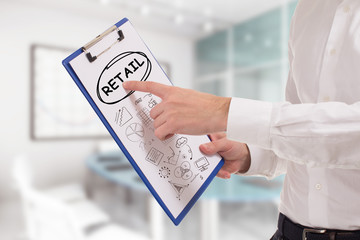 Business, technology, internet and network concept. Young businessman points to the keyword: Retail