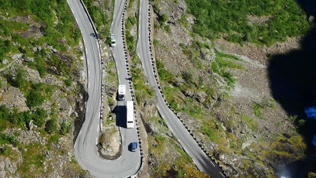 Aerial view of coach bus and other vehicles meeting on Trollstigen or Trolls Path, a popular narrow serpentine mountain road with 11 hairpin turns near Andalsnes, Norway.