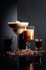 Coffee cocktails, espresso and coffee liquor on black reflective background.