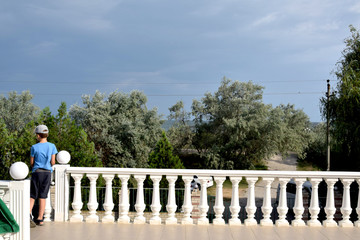 Ancient balustrade on the balcony and a marble staircase on a summer day