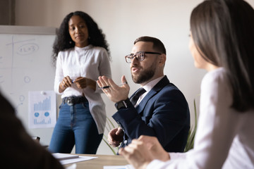 Confident male business leader talking during group office briefing