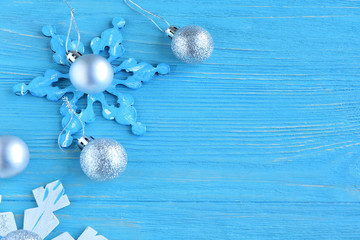 New Year 2020 flat lay with wooden snowflakes and silver sparkle decorative ball on blue textured background, selective focus. Christmas and New Year flat lay with shiny decorations on blue backdrop 