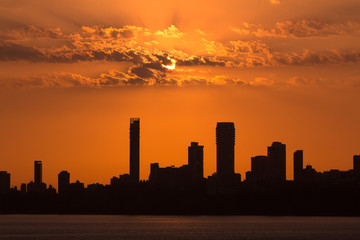 Fototapeta na wymiar Silhouette shot of Mumbai Skyline at Sunset as seen from Marine Drive