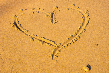 Heart drawn in the sand. Beach background. Top view