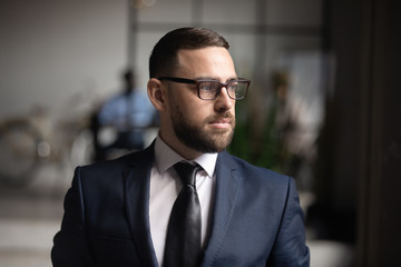 Serious thoughtful businessman wear suit looking away thinking of future