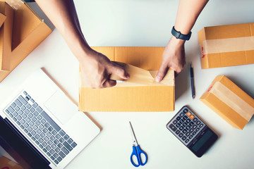 Shipment Online Sales .Man worker delivery service and working packing box, business owner working checking order to confirm before sending customer in post.Top view - obrazy, fototapety, plakaty