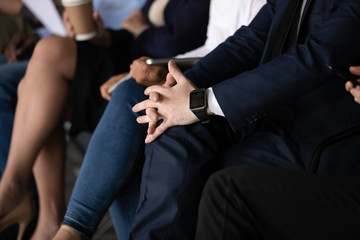 Businessman with clasped hands waiting in queue, close up view