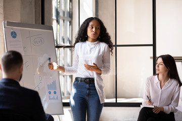 Confident african conference conductor give flip chart presentation at training